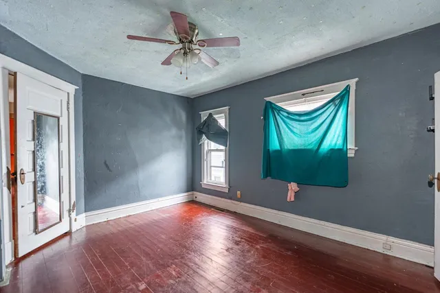a view of room with wooden floor and ceiling fan