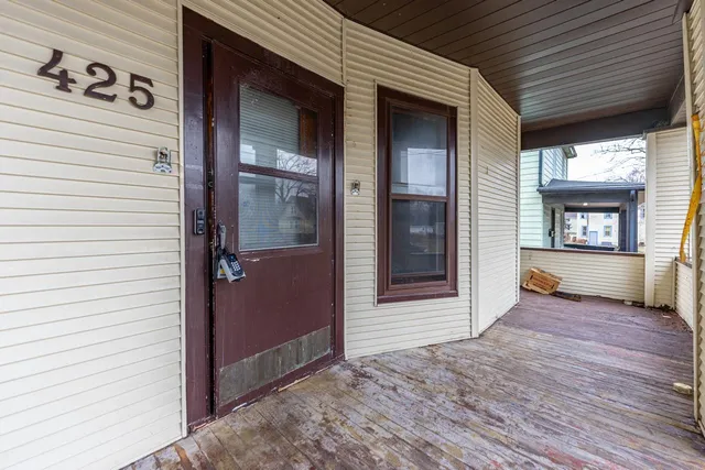 an empty room with wooden floor and a hallway