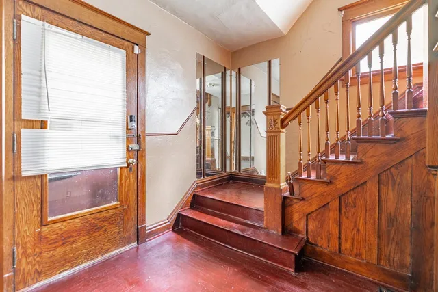 a view of staircase with wooden floor and a large window