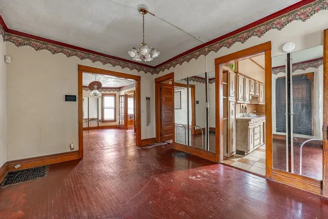 a view of a hallway with wooden floor and door