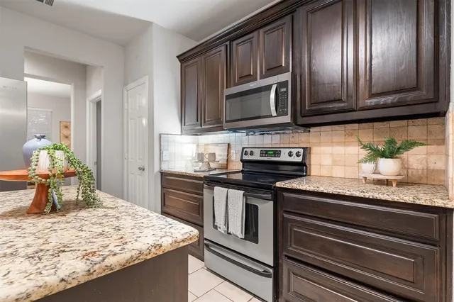 a kitchen with stainless steel appliances granite countertop a stove microwave and refrigerator
