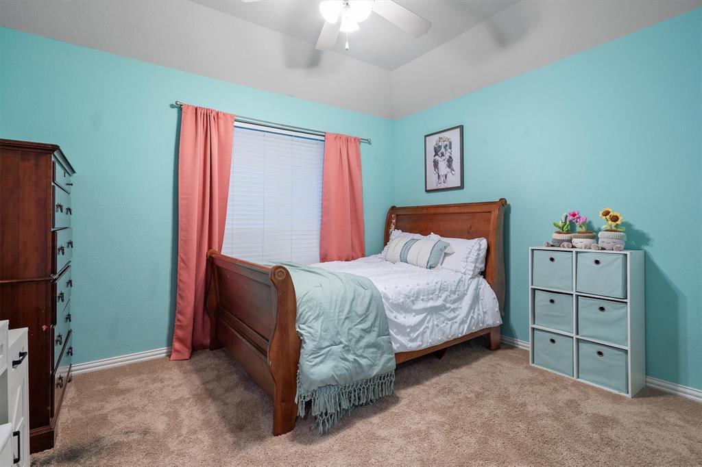 1501 Valley Creek Road Denton, TX 76205 - Photo 26 of 40 a bedroom with a bed and a chandelier