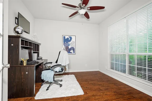 a view of a workspace with furniture and a window