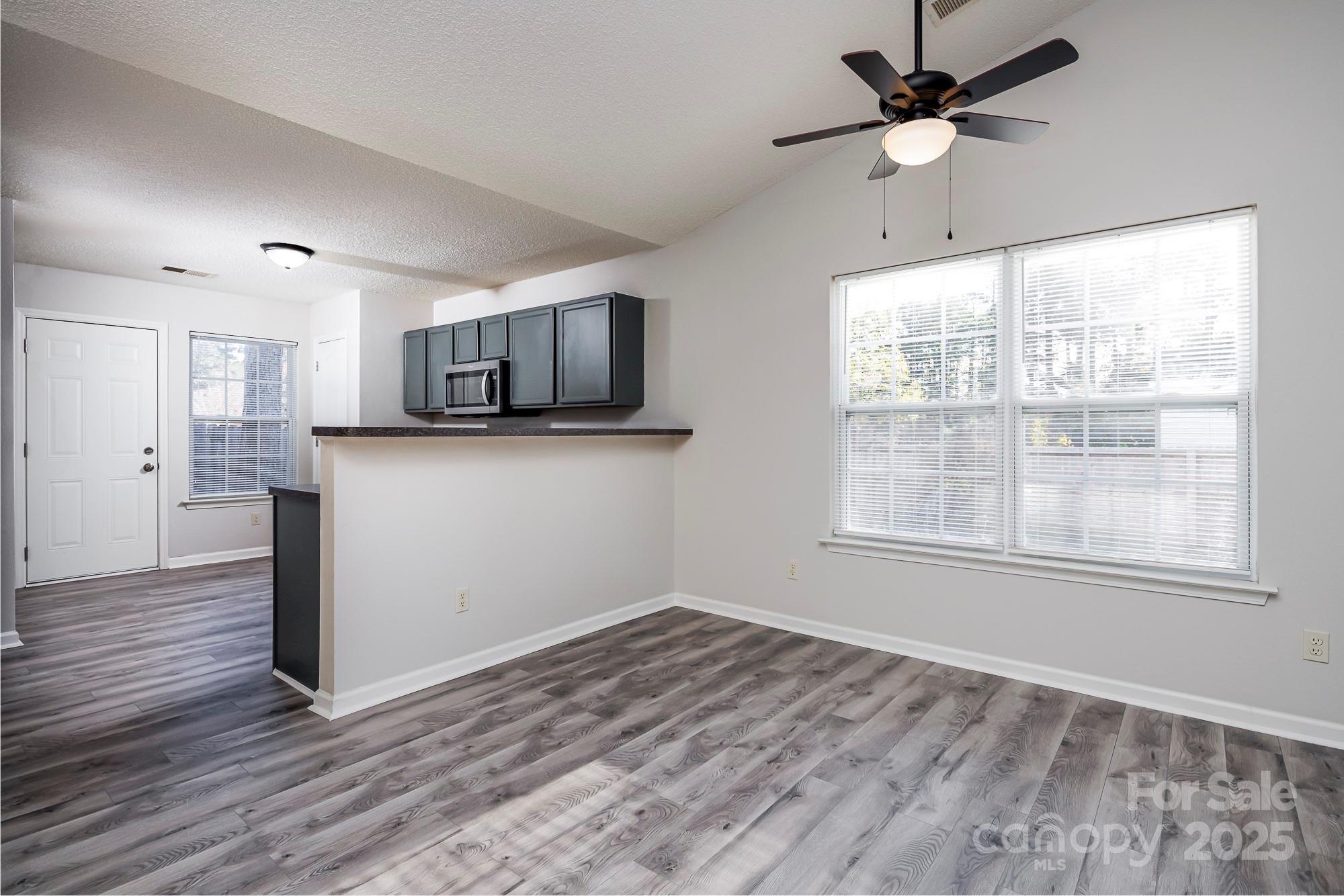 162 None Road Columbia, SC 29223 - Photo 4 of 24 a view of a kitchen with a microwave and wooden floor