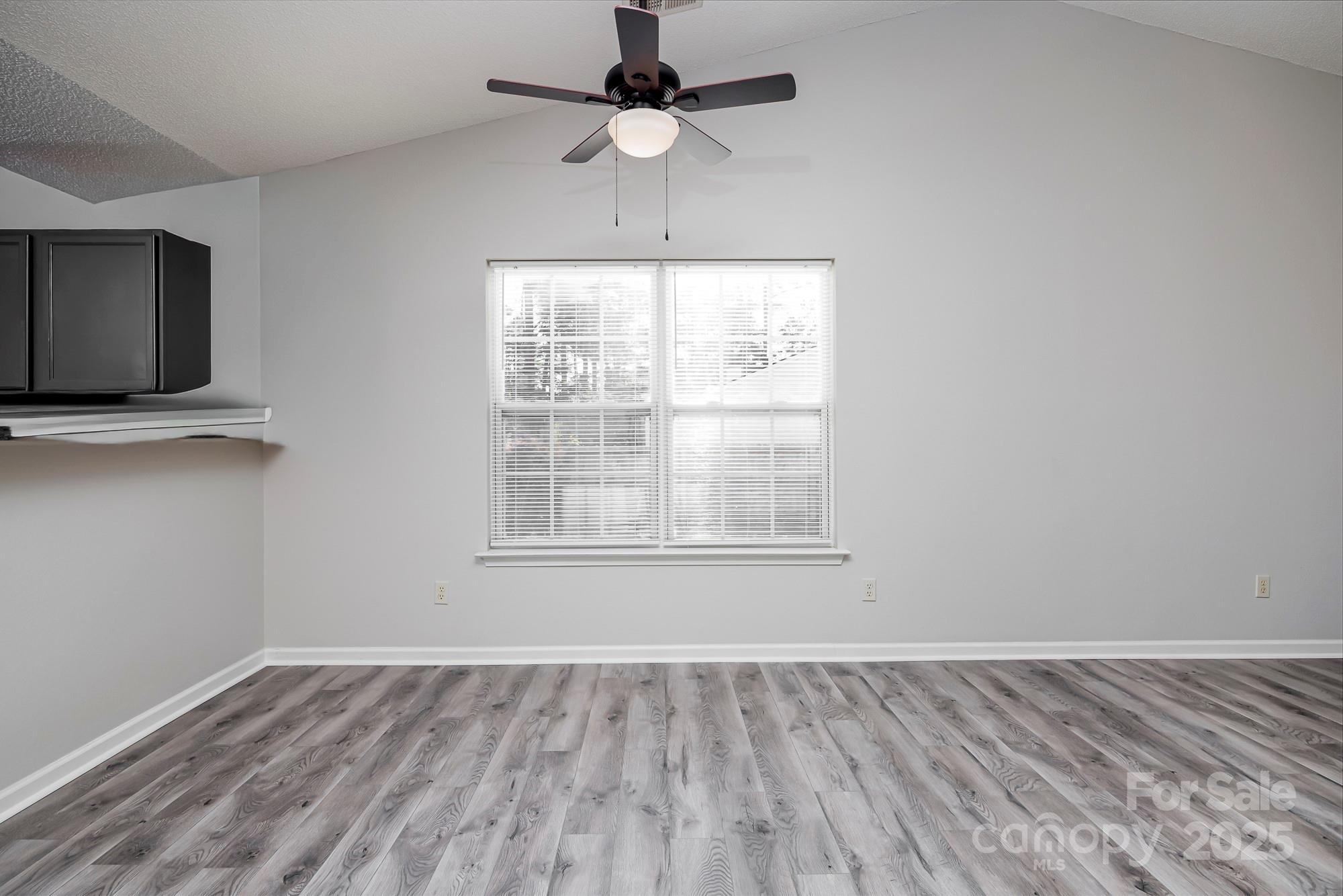 162 None Road Columbia, SC 29223 - Photo 5 of 24 an empty room with wooden floor chandelier fan and windows