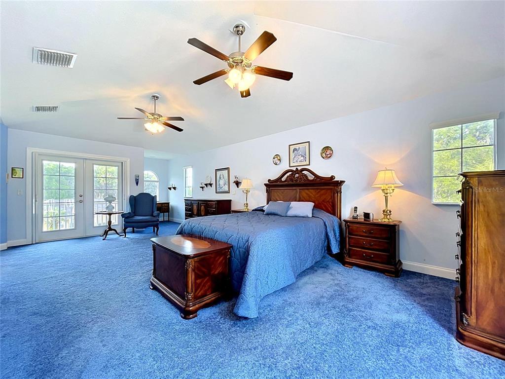 1360 South Waterview Drive Inverness, FL 34450 - Photo 79 of 100 a spacious bedroom with a bed and a chandelier
