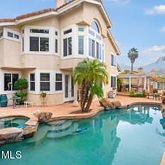 a view of a white house with a yard table and chairs