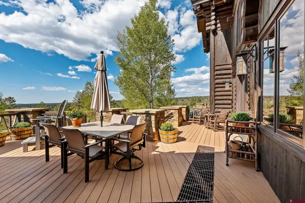 a view of a roof deck with table and chairs with wooden floor and fence