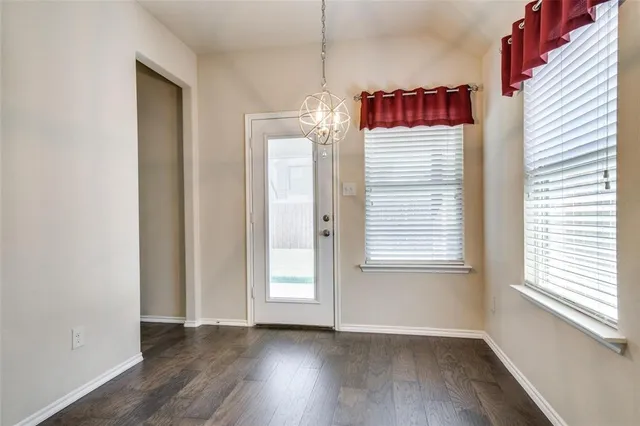 a view of a bedroom with wooden floor and windows