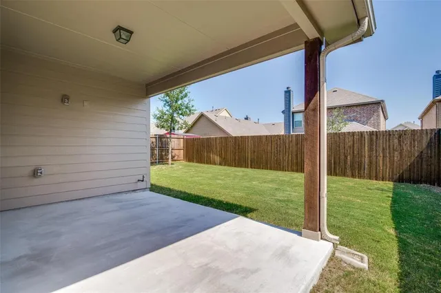 a view of backyard with wooden fence