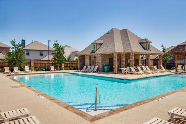 a view of a house with a swimming pool and sitting area
