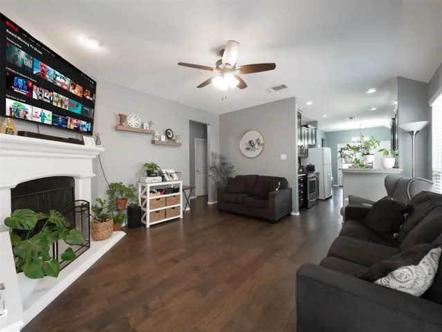 a living room with furniture a fireplace and a ceiling fan