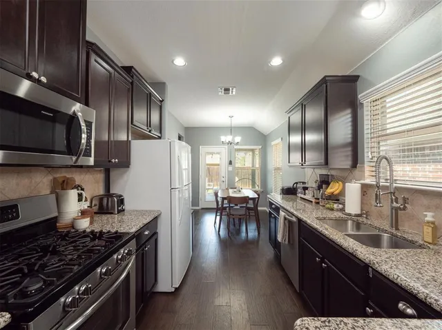a kitchen with lots of counter top space a sink appliances and cabinets