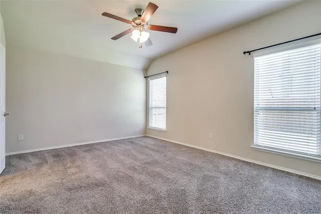 an empty room with windows and fan