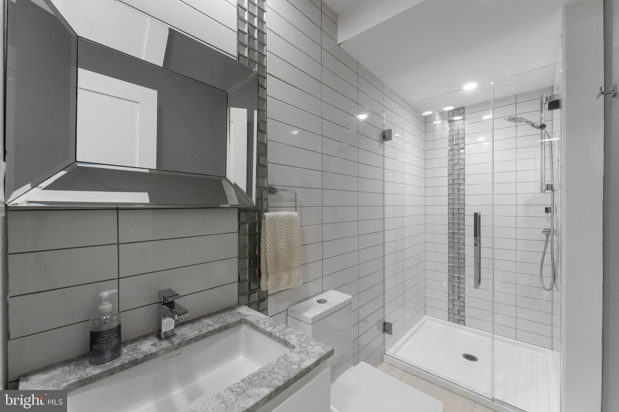 11587 Maple Ridge Road Reston, VA 20190 - Photo 17 of 119 a bathroom with a granite countertop sink a toilet and shower