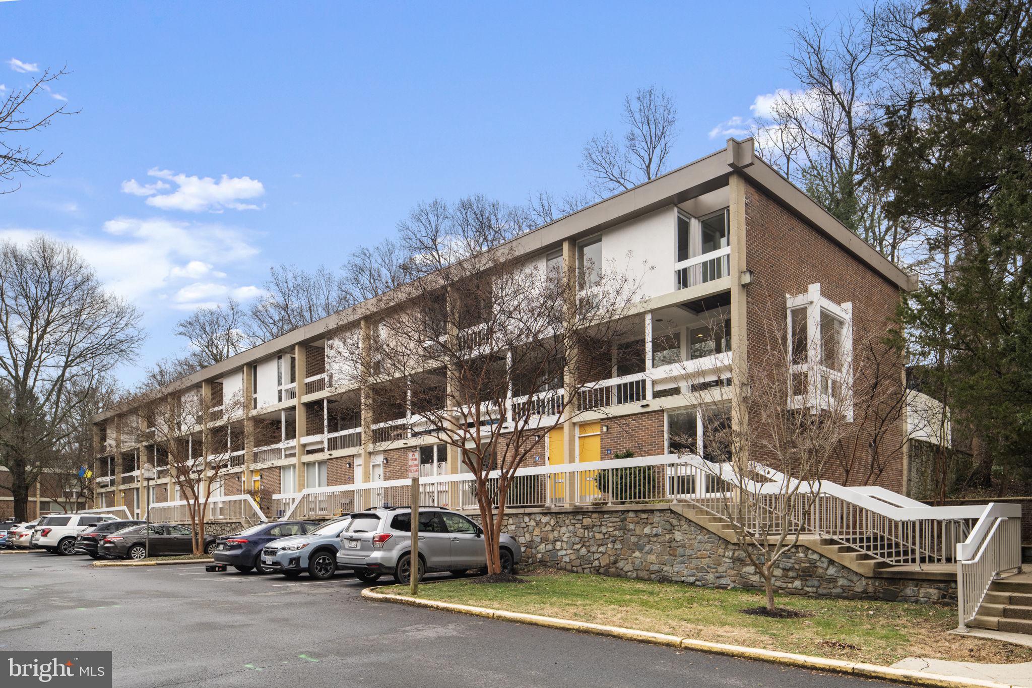 11587 Maple Ridge Road Reston, VA 20190 - Photo 83 of 119 a front view of a building with lot of cars and trees