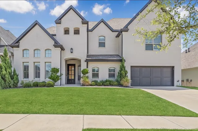 a front view of a house with a garden and pathway