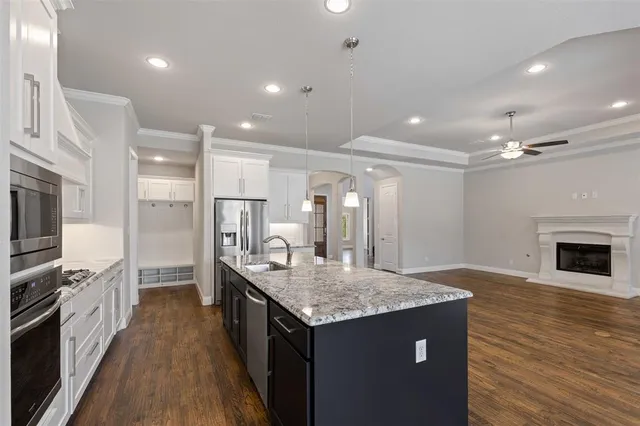 a kitchen with granite countertop kitchen island a sink appliances and a counter top space