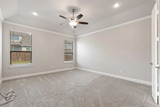 an empty room with windows and fan