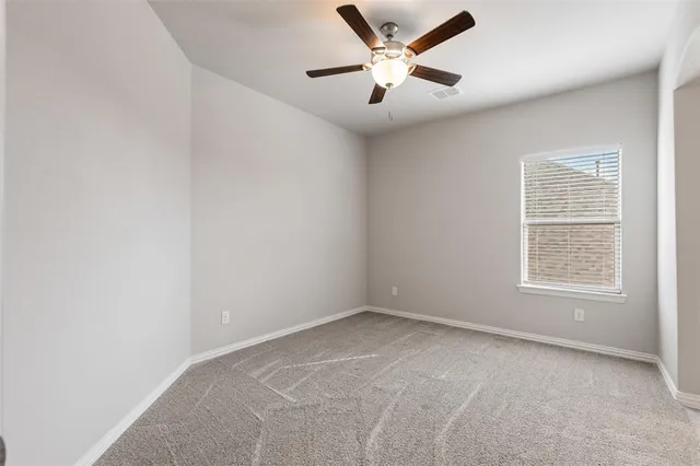 an empty room with a window and a ceiling fan