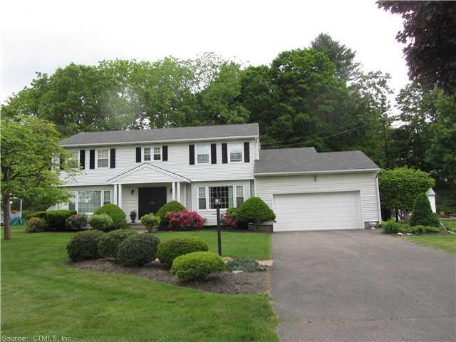a front view of a house with a garden and plants