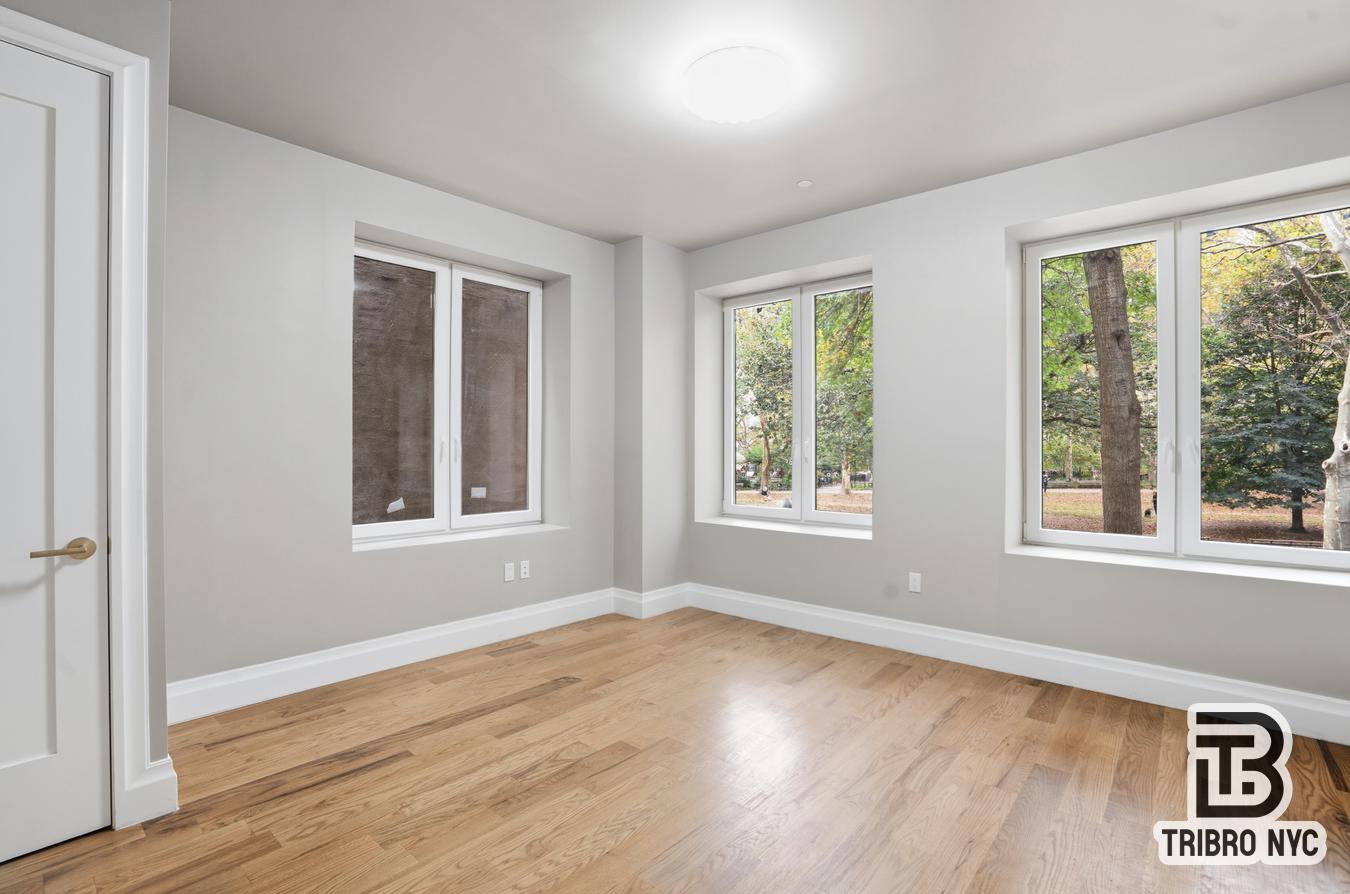 129 Russell Street, Unit 2A Brooklyn, NY 11222 - Photo 4 of 7 a view of an empty room with wooden floor and a window