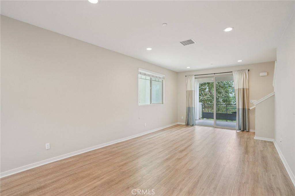 143 Frame Irvine, CA 92618 - Photo 8 of 41 a view of an empty room with wooden floor and a window
