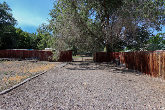 270 East 100 North Monroe, UT 84754 - Photo 55 of 65 Expansive gravel area bordered by a wood fence and mature trees
