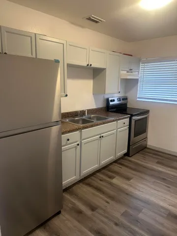 a kitchen with stainless steel appliances a refrigerator sink and cabinets