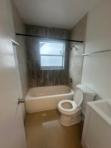 a bath room with a toilet and a bath tub
