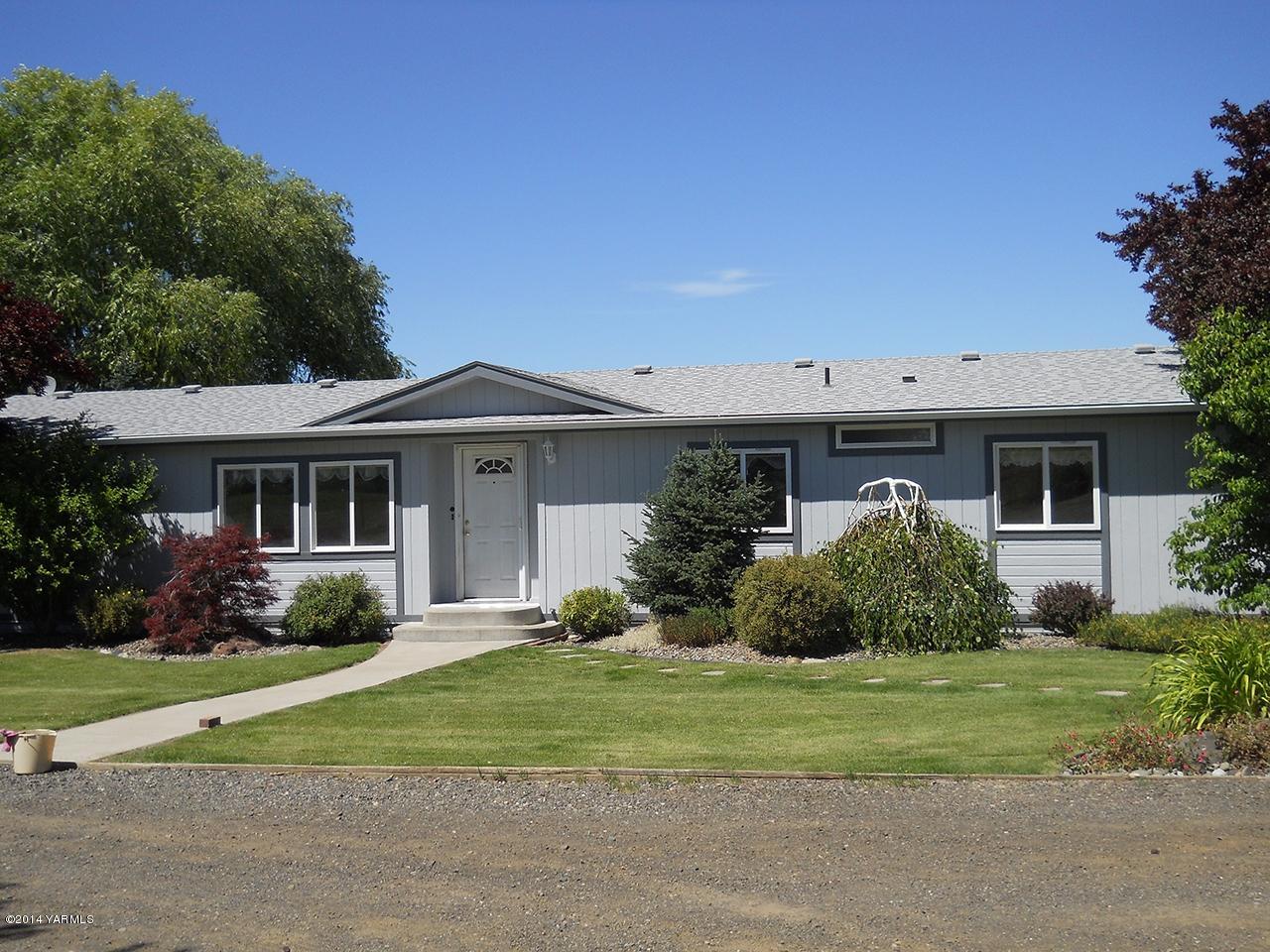 15601 Fisk Road Yakima, WA 98908 - Photo 1 of 58 a front view of a house with a garden and plants