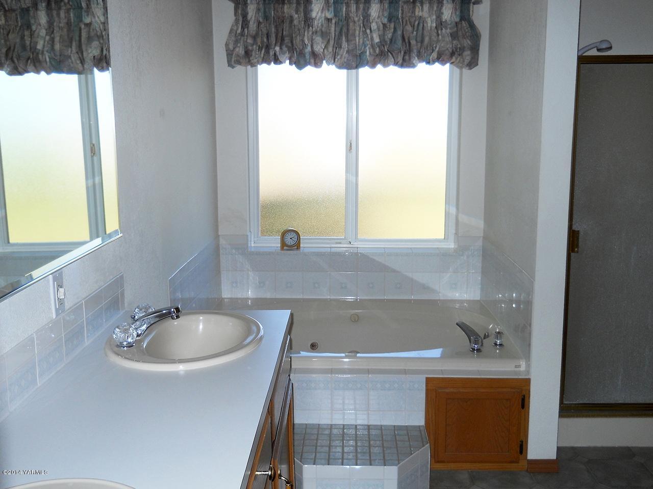 15601 Fisk Road Yakima, WA 98908 - Photo 18 of 58 a bathroom with a sink a bathtub and next to a window