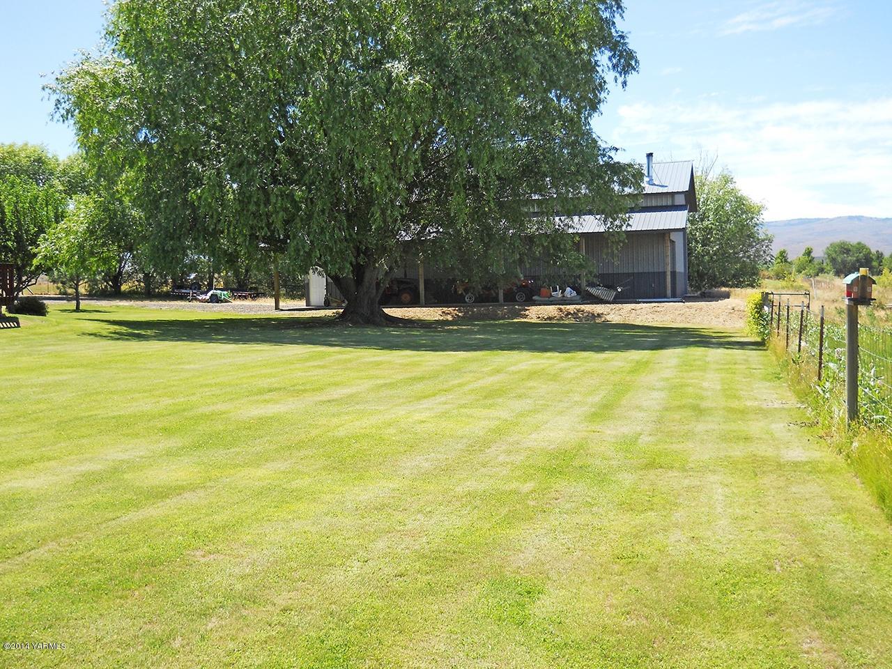 15601 Fisk Road Yakima, WA 98908 - Photo 33 of 58 a view of a swimming pool with lawn chairs and large trees