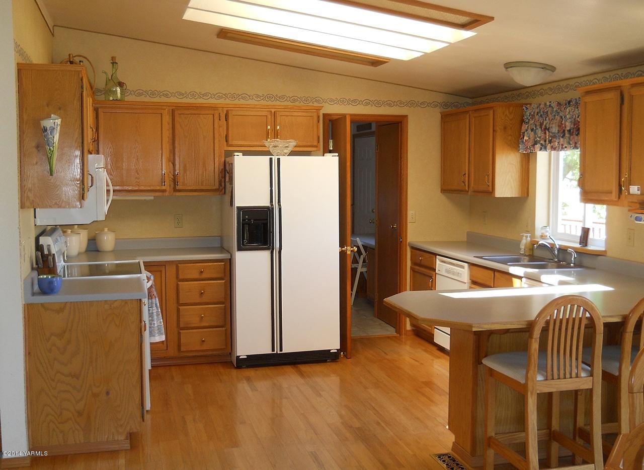 15601 Fisk Road Yakima, WA 98908 - Photo 10 of 58 a kitchen with kitchen island a counter top space a sink stainless steel appliances and cabinets