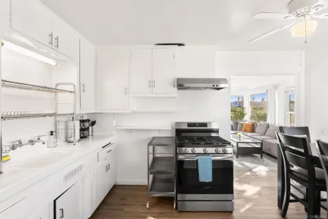 a kitchen with cabinets stainless steel appliances and wooden floor