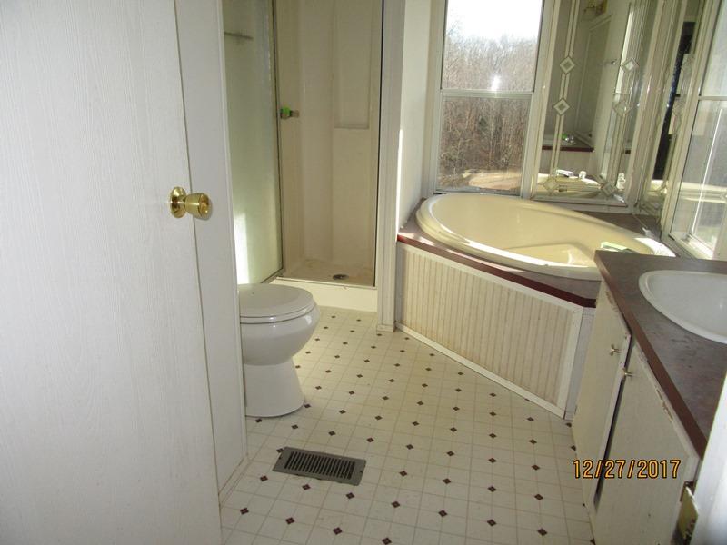 2408 Graham Cemetery Road Clarksville, TN 37043 - Photo 6 of 7 a bathroom with a sink a toilet a mirror and shower