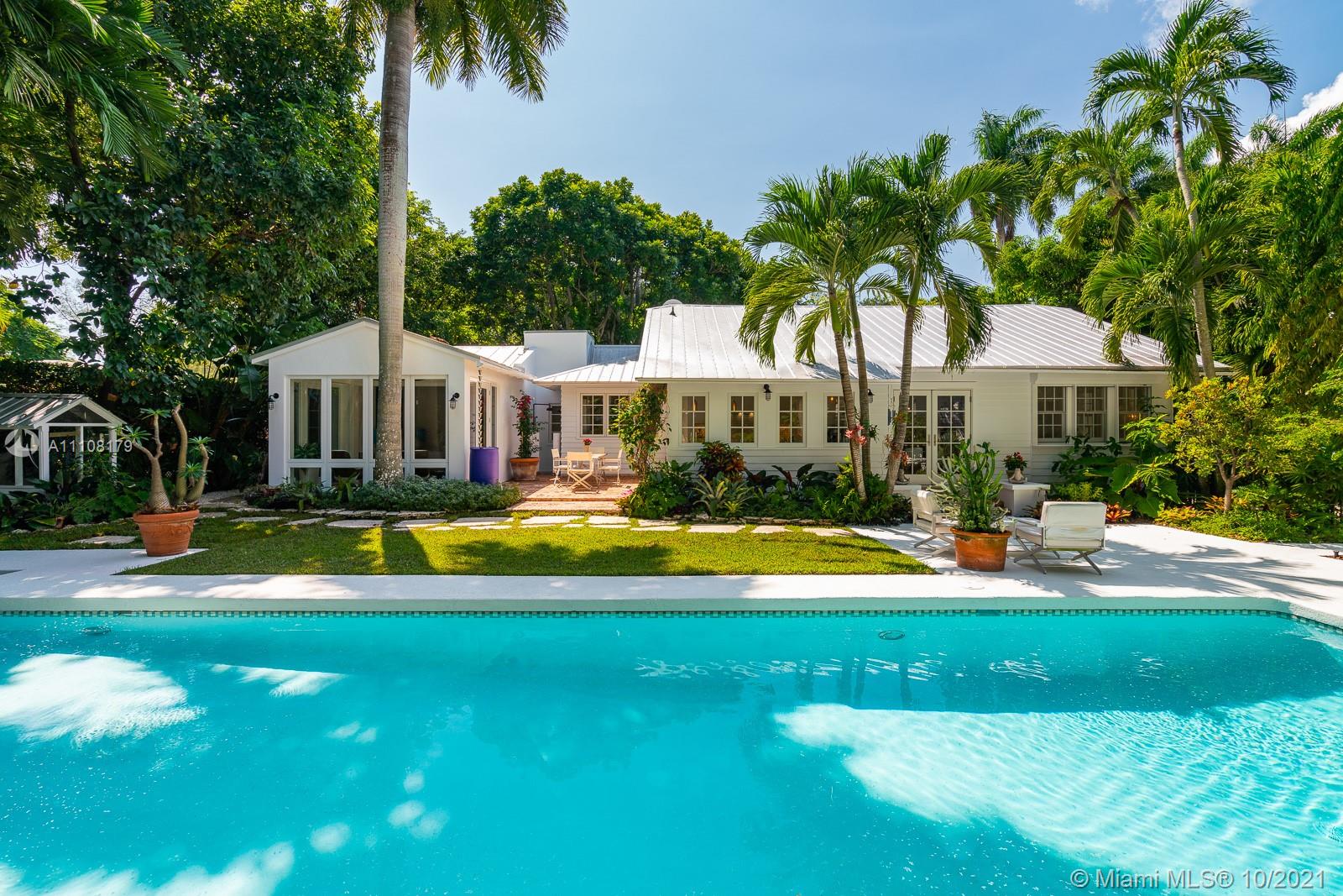 a view of swimming pool with lawn chairs and plants