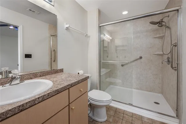 a bathroom with a granite countertop sink toilet and shower