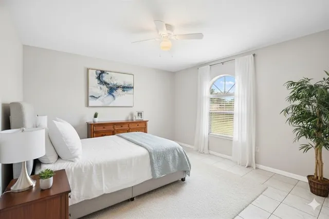 a bedroom with a bed and a potted plant