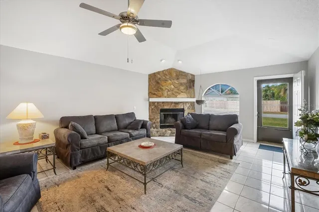 a living room with furniture a ceiling fan and a window