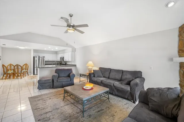 a living room with furniture and kitchen view