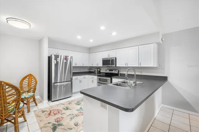 a kitchen with stainless steel appliances granite countertop a sink refrigerator and microwave