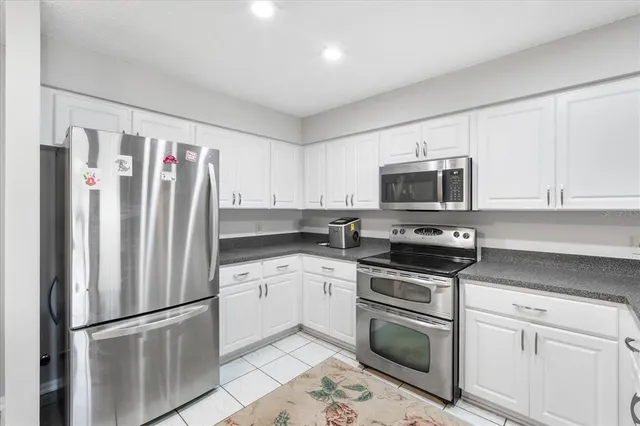 a kitchen with stainless steel appliances granite countertop a refrigerator stove a sink and a microwave