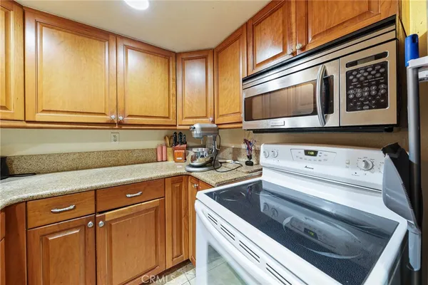 a kitchen with stainless steel appliances granite countertop a refrigerator a sink and a stove