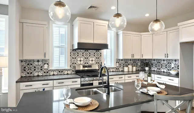 a kitchen with living room and chandelier
