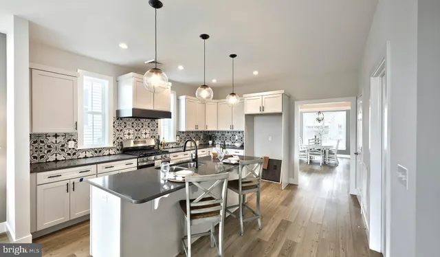 a kitchen with stainless steel appliances kitchen island a large island a stove a table and chairs in it