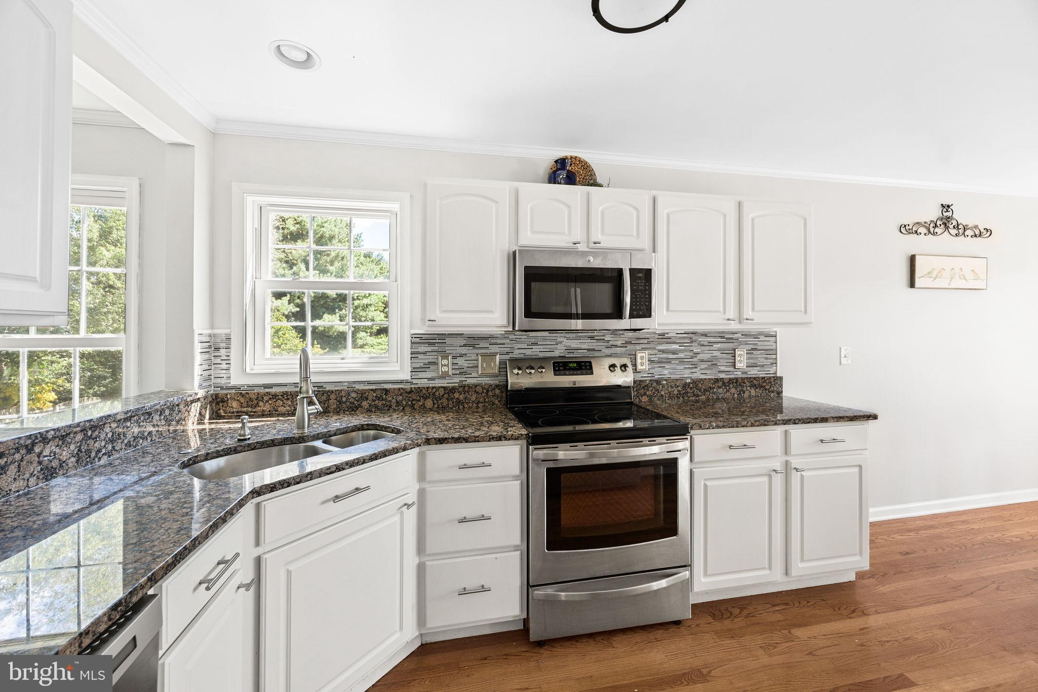 60 Trix Court Ranson, WV 25438 - Photo 15 of 47 a kitchen with white cabinets appliances a sink and a window
