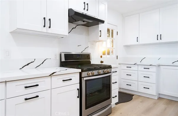 a kitchen with cabinets appliances and a wooden floor