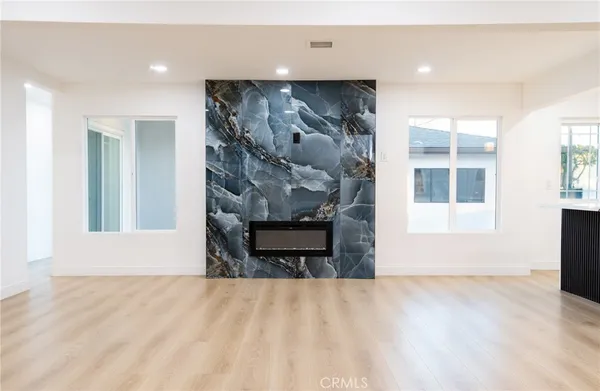 a big room with wooden floor and a window