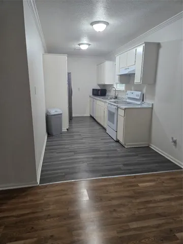 a large kitchen with cabinets wooden floor and stainless steel appliances